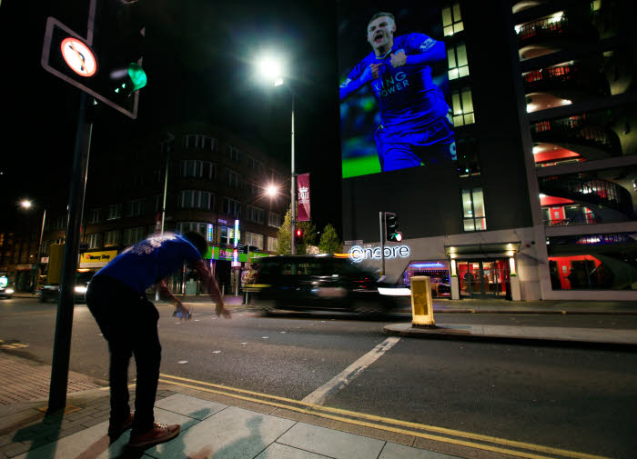 A Leicester City fan bows down to a projection of Jamie Vardy on the side of the Ramada Encore Hotel in Leicester after Leicester City were crowned Barclays Premier League champions following Tottenham Hotspur's 2-2 draw against Chelsea. Photo : Jonathan Brady / PA Images / Icon Sport