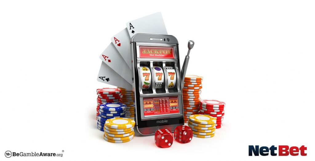 Phone with slot game on screen surrounded by cards and chips